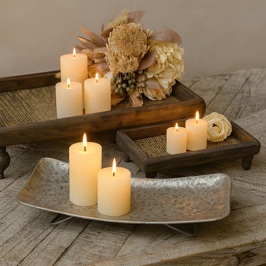 Hangulatos enteriőr, ahol egy fémlábas, kalapált felületű bádog tálat két gyertya és háttérben egy romantikus szárazvirág csokor díszít.