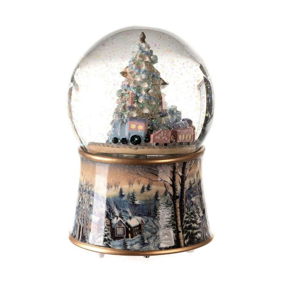 Karácsonyi zenélő-forgó csillámos hógömb, ünnepi karácsonyfával körülötte játék mozdonnyal.