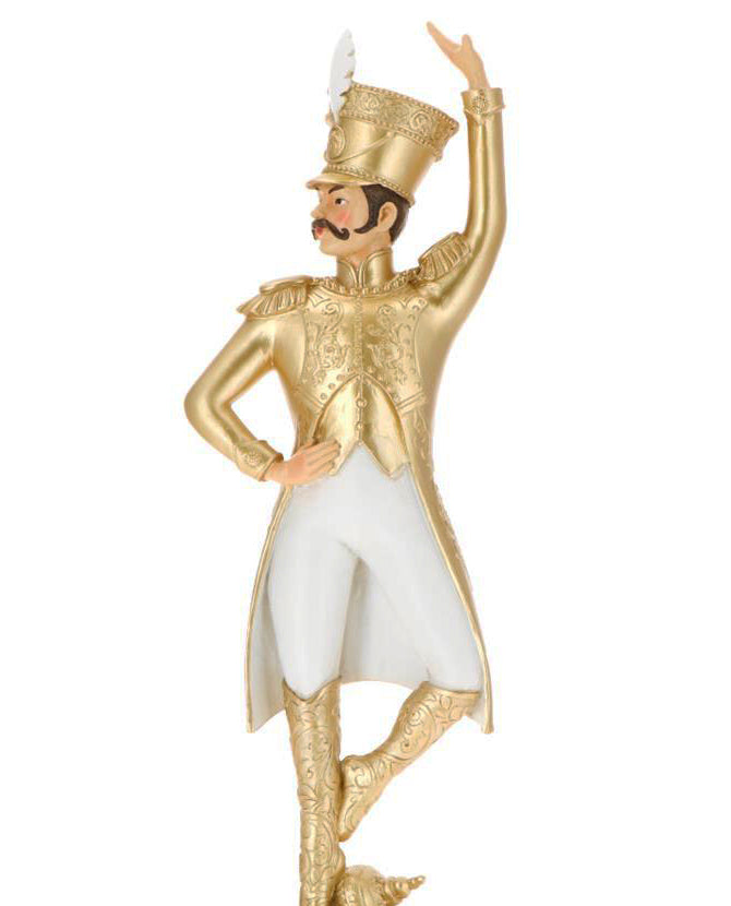 Arany és fehér színárnyalatú, táncoló karácsonyi katona figura.