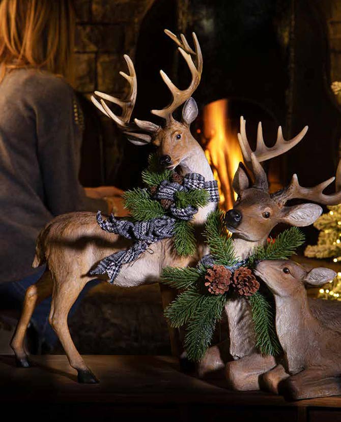 Ünnepi fenyővel és masnival díszített karácsonyi szarvas család.