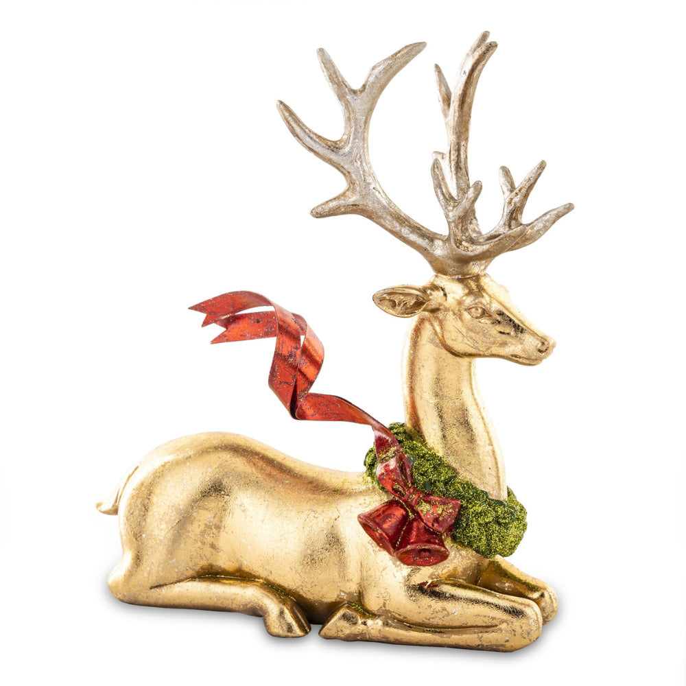 Piros színű fémmasnival díszített, fényes felületű, aranyszínű karácsonyi szarvas figura.