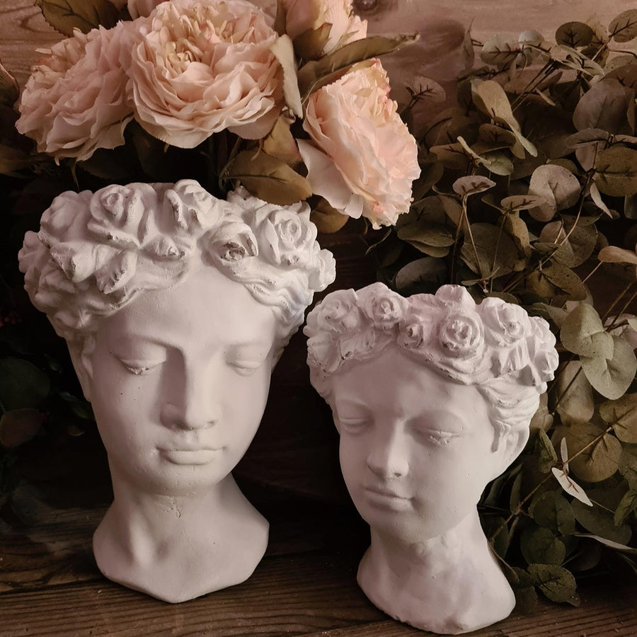 Antikolt felületű, krém színű kaspó büszt.