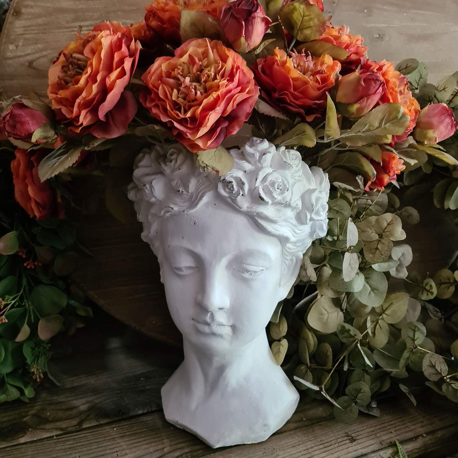 Antikolt felületű, krém színű kaspó büszt.