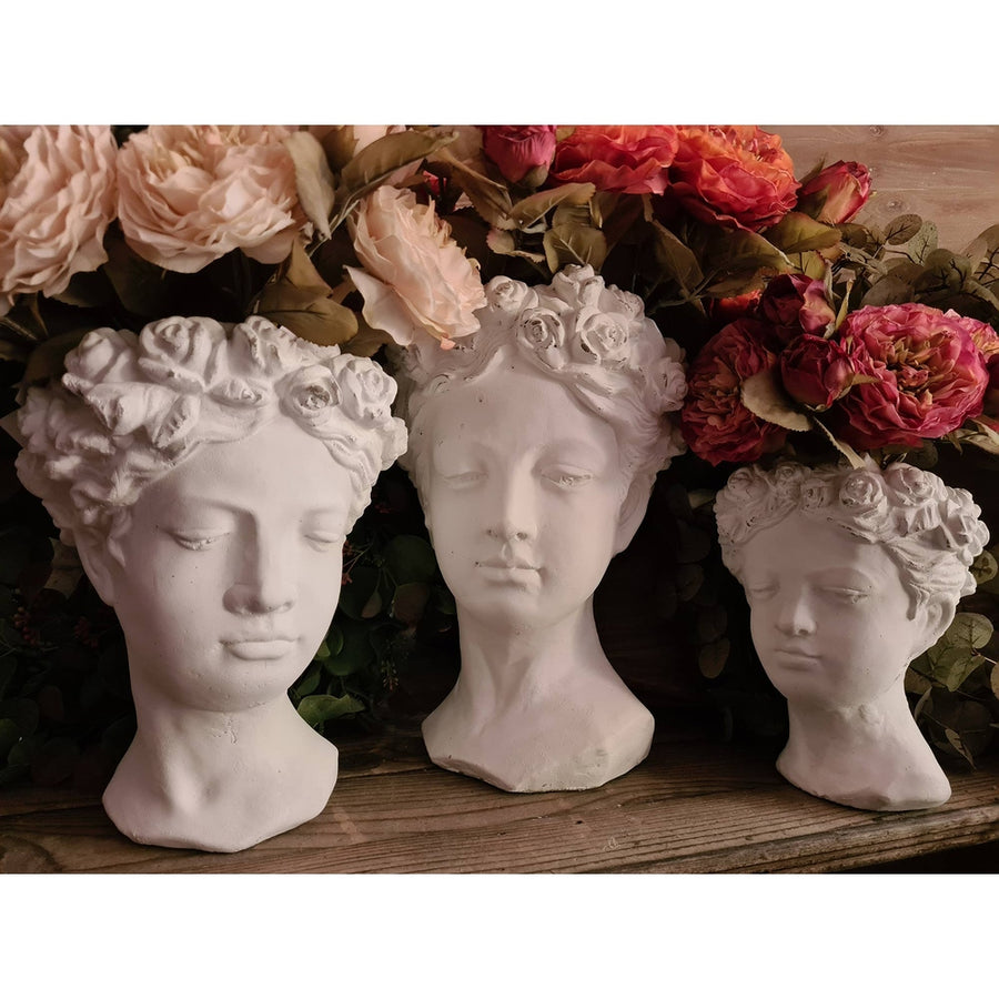 Antikolt felületű, krém színű kaspó büszt.