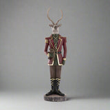 Plüssmackót tartó karácsonyi szarvas figura.