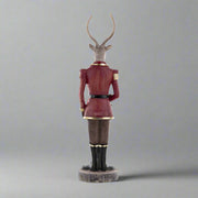 Plüssmackót tartó karácsonyi szarvas figura.