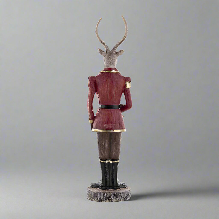 Plüssmackót tartó karácsonyi szarvas figura.