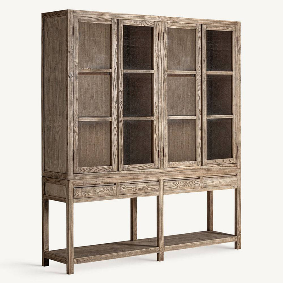 Ferde nézet: Kortárs stílusú, világos szilfából készült Masein vitrines szekrény oldalról.