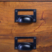 Mangófafiókra szerelt fekete színű perselyes fogantyú.