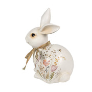 Mezei virágokkal és bézsszínű masnival díszített húsvéti nyuszi figura..