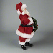 Koszorút tartó, piros színű Mikulás figura.