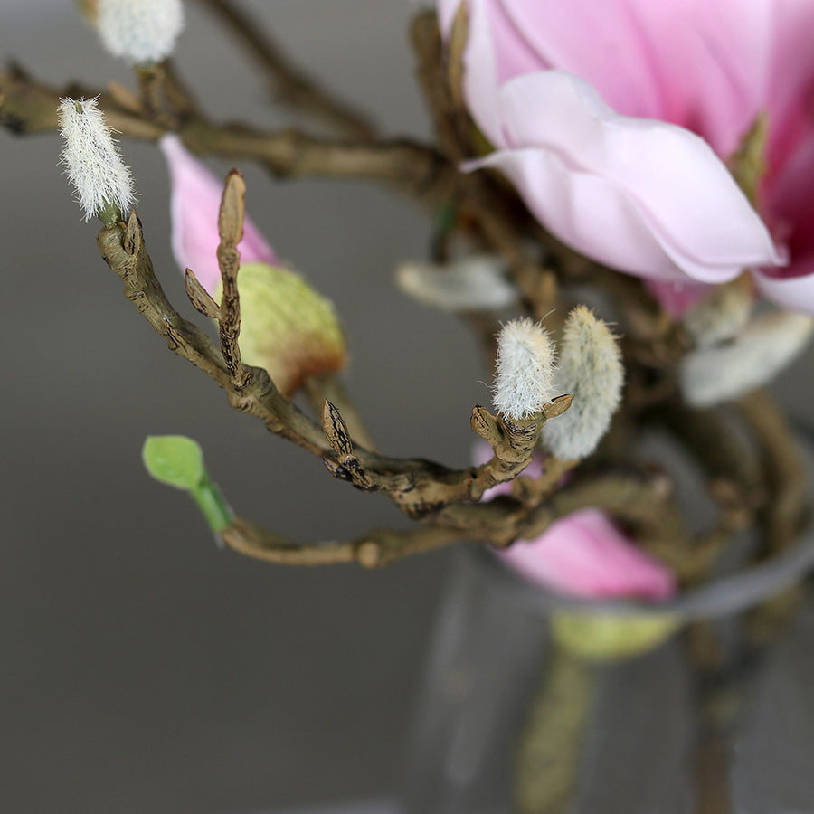 Halvány rózsaszín színű, mű magnólia kompozíció, modern formájú üvegvázában..