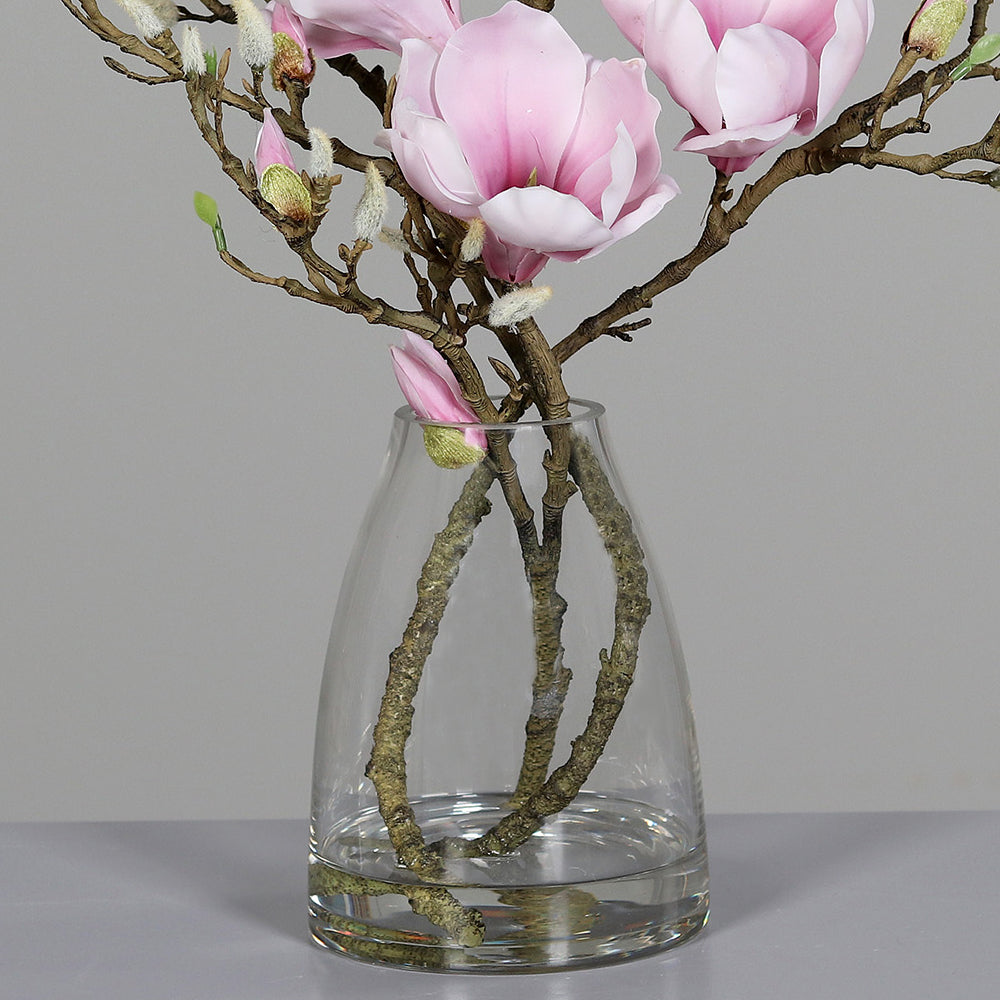 Halvány rózsaszín színű, mű magnólia kompozíció, modern formájú üvegvázában..