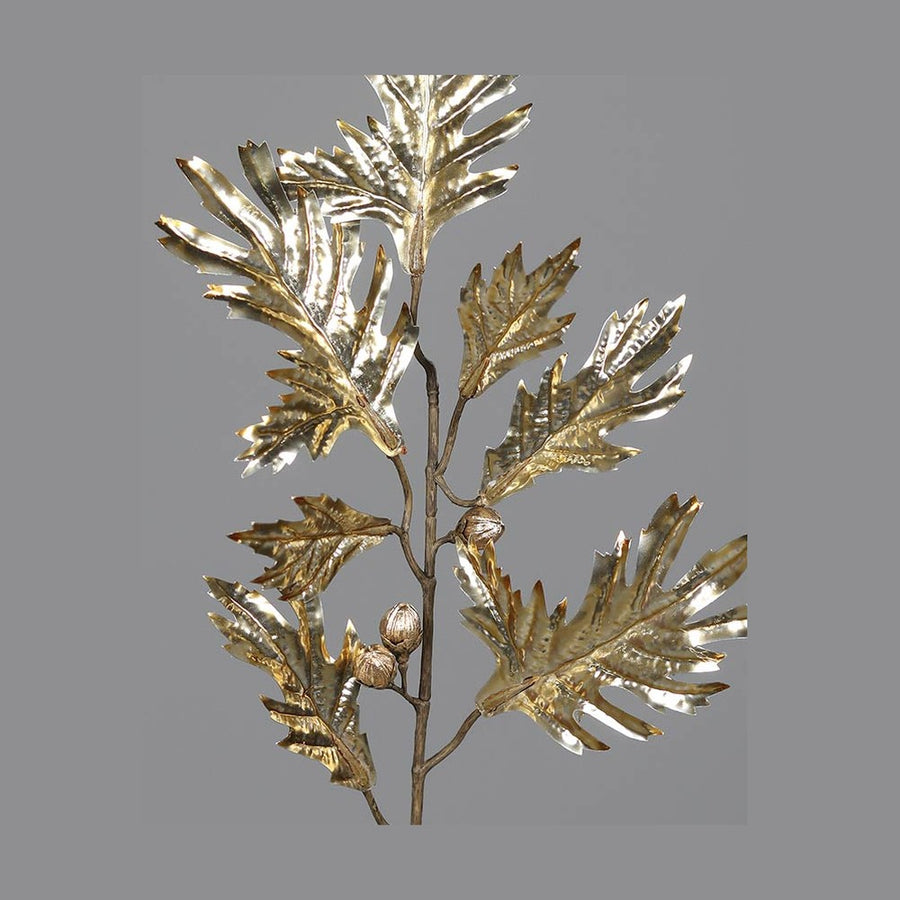 Fényes, aranyszínű levelekkel és termésekkel kialakított mű tölgyfa ág.