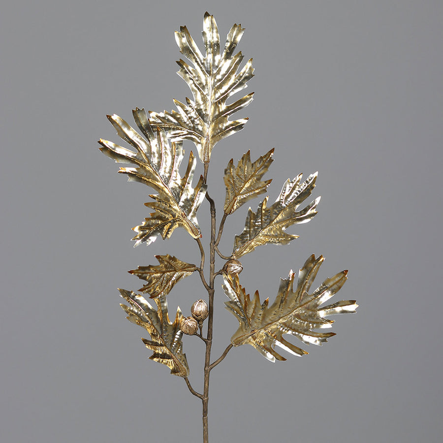 Fényes, aranyszínű levelekkel és termésekkel kialakított mű tölgyfa ág.