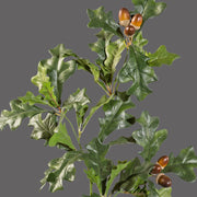 Makkokkal díszített, zöld színű, mű tölgyfa ág.