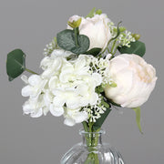 Krémszínű, vegyes művirágokból készült virágcsokor üvegvázában..