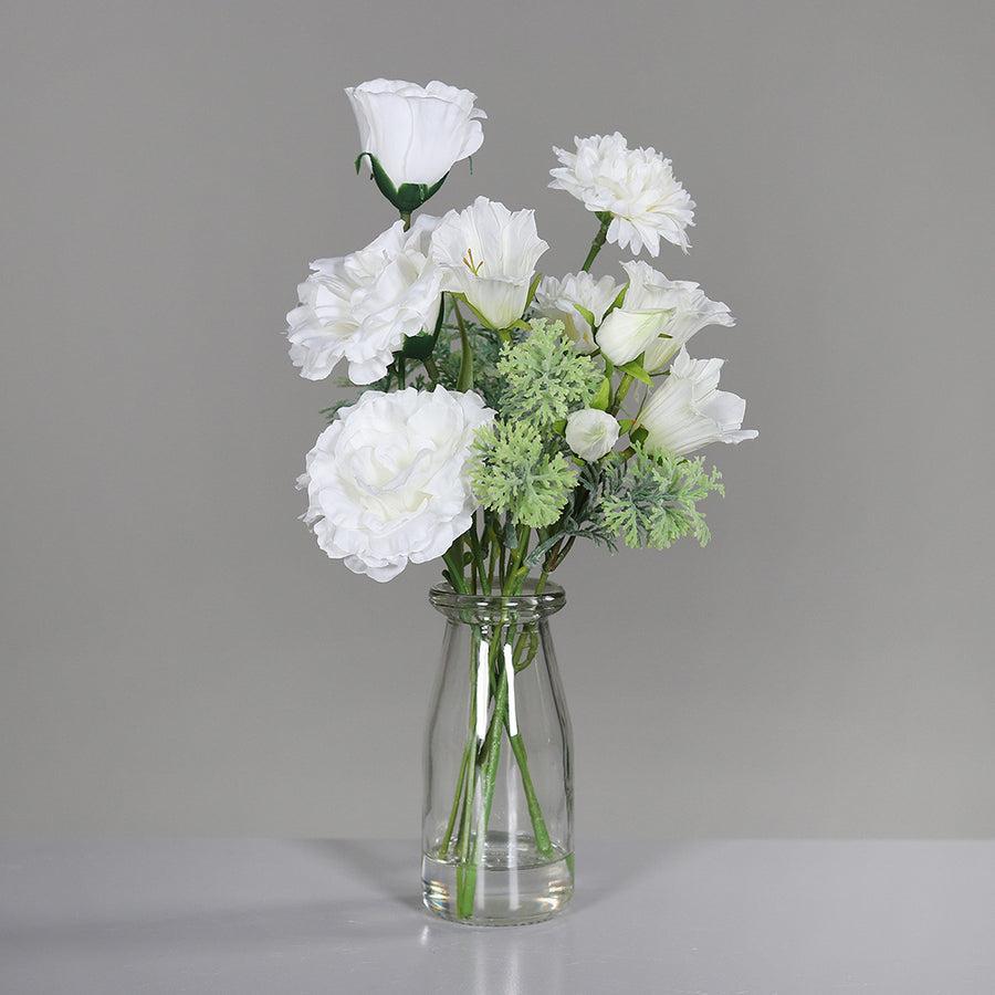 Krémszínű, vegyes művirágokból készült kompozíció, áttetsző üvegvázában..