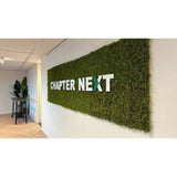 Muscus UV-álló mű rénszarvas moha panelből készült dekorációs fal, fehér “Chapter Next” felirattal.