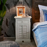 Fehér akácfa éjjeliszekrény hálószobai enteriőrben, dekorációval és lámpával