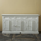 Klasszikus fehér komód lamellás ajtókkal fa padlón