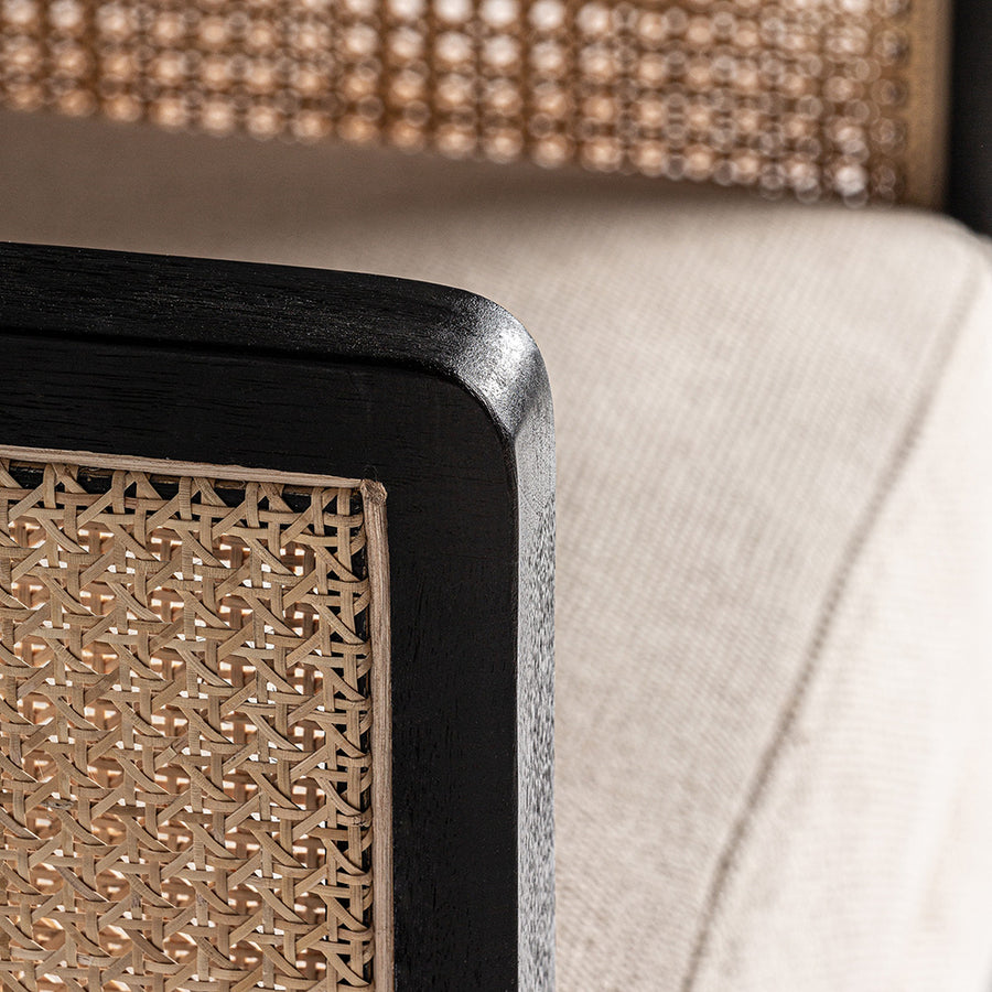 Fekete színre festett mangófából készült, rattan betétes kialakítású, bézs színű szövettel kárpitozott fotel.