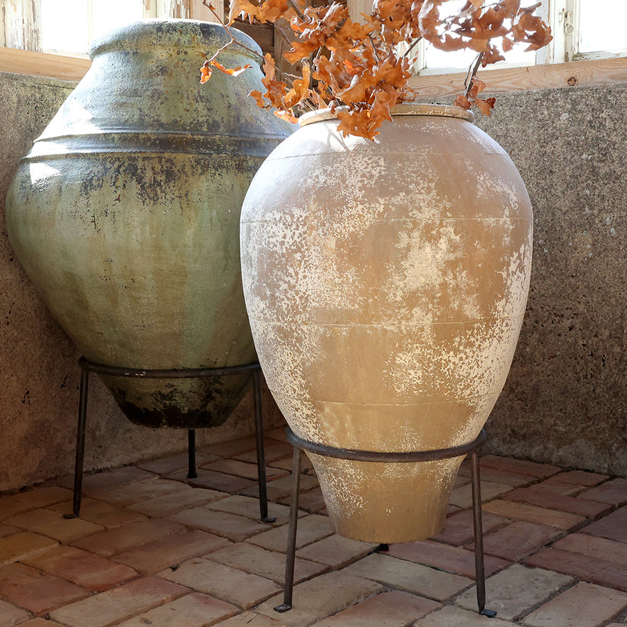 Antik krém színű Odin lábas kaspó beltéri elhelyezésben, zöld kaspó mellett