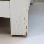 Antik krém szekrény lábazatának részlete patinás festéssel