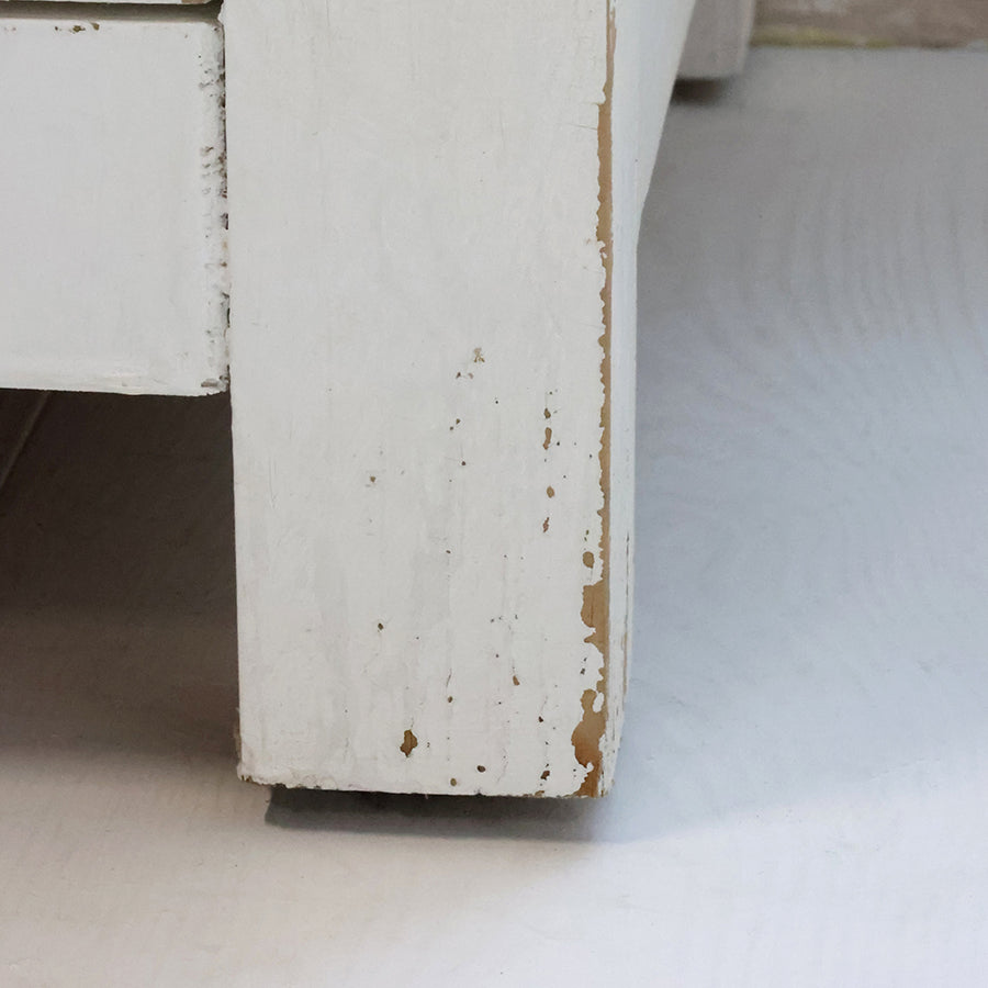 Antik krém szekrény lábazatának részlete patinás festéssel