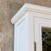 Közelkép az Old French szekrény díszléces, fehérre festett felső éléről és ajtókeretéről.