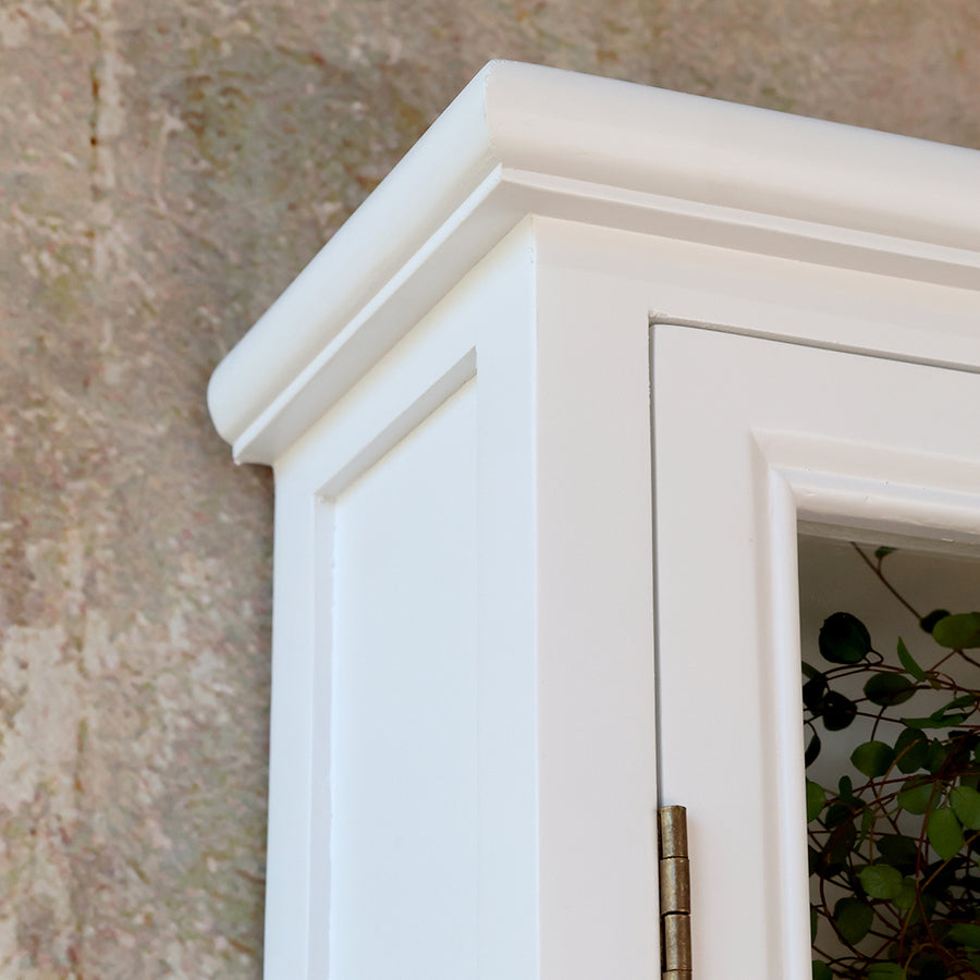 Közelkép az Old French szekrény díszléces, fehérre festett felső éléről és ajtókeretéről.