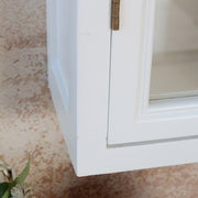 Közelkép az Old French szekrény alsó sarokrészéről, az elegáns íves díszítéssel és festett fa felülettel.