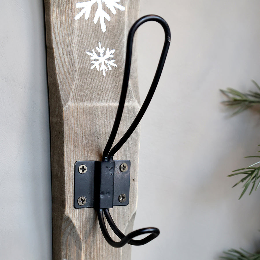 Antik hatású fali fogas vas akasztóval és kézzel festett hópelyhekkel közelről