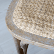 A kézműves rattan ülőfelület és fa keret találkozása közelről