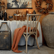 Vidéki hangulatú enteriőr gyertyákkal és terített asztallal, háttérben az Old French natúr étkezőszékkel.