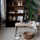 OLD FRENCH natúr színű kaucsukfa rattan pad nappali enteriőrben, dekoratív kosarakkal és gyertyákkal