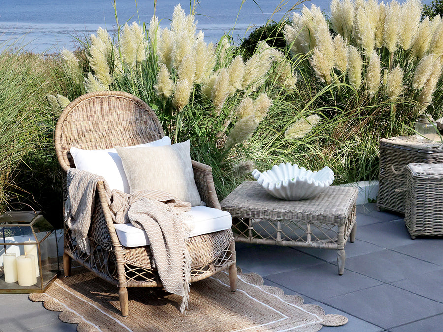 OLD FRENCH rattan fotel kültéri környezetben, természetes textíliákkal kiegészítve