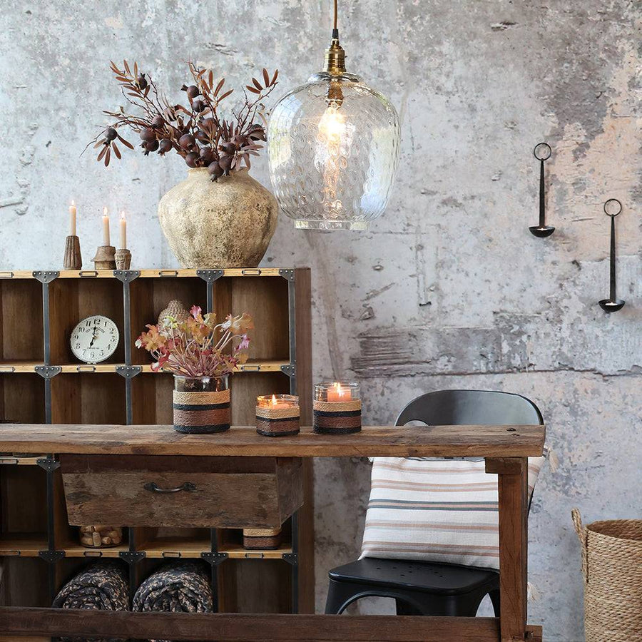 Vintage stílusú fal és faasztal fölött függő Old French üveg függeszték lámpa, meleg fényben.