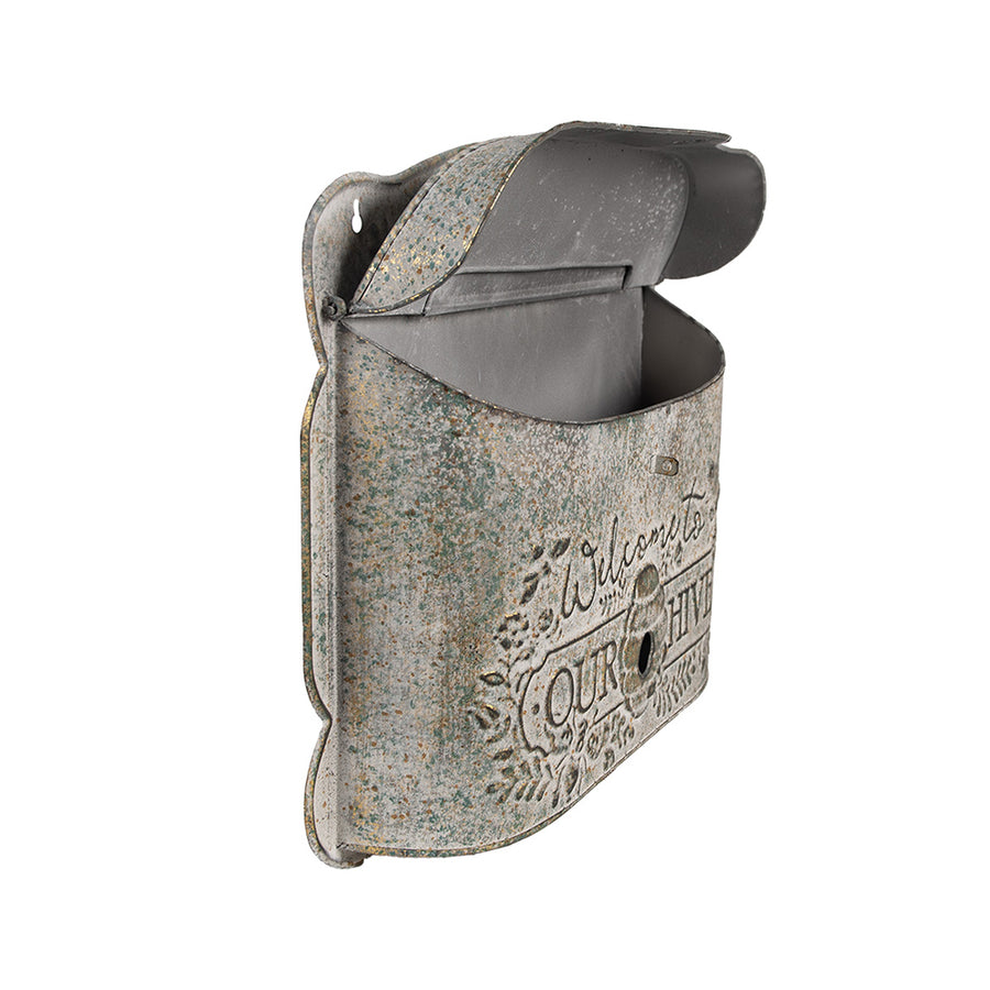 Nyitott postaláda szögből fotózva, látható belső térrel és antikolt fém felülettel.