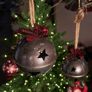 Piros színű fém masnival díszített karácsonyi kézműves bádogcsengő.