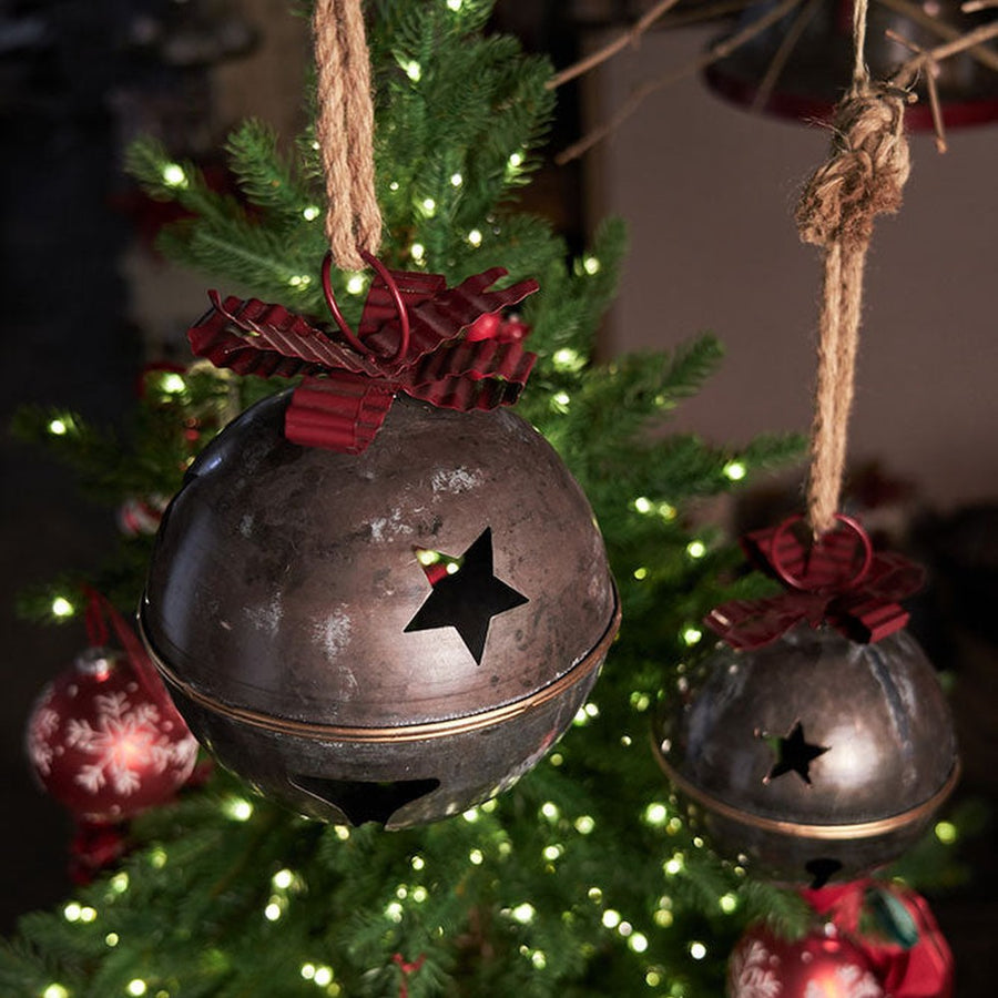 Piros színű fém masnival díszített karácsonyi kézműves bádogcsengő.