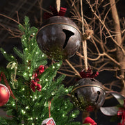 Piros színű fém masnival díszített karácsonyi kézműves bádogcsengő.