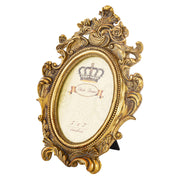Barokkos levéldíszekkel díszített, antikot felületű, aranyszínű asztali fényképtartó képkeret.
