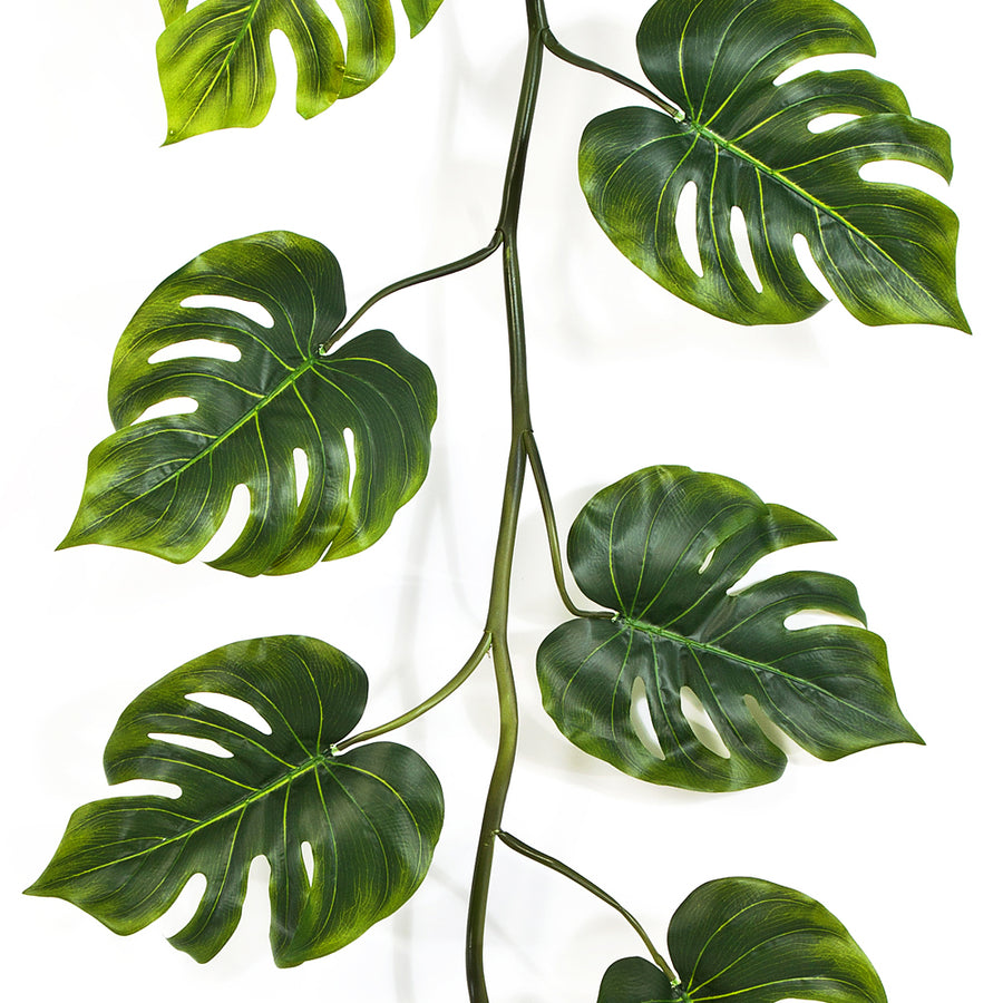 A Philodendron mű filodendron girland szeldelt zöld levelei közelről, világosabb erezettel és váltakozó levélállással a vékony száron.