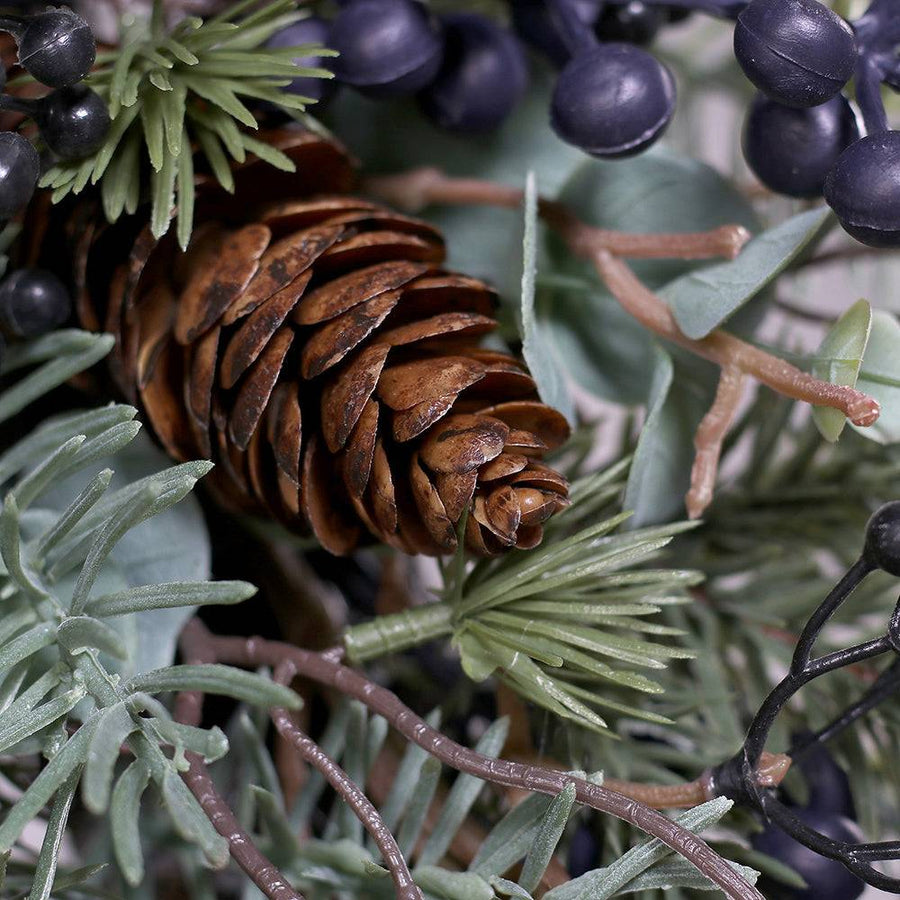 PINE koszorú toboz részlete fenyőágak között.