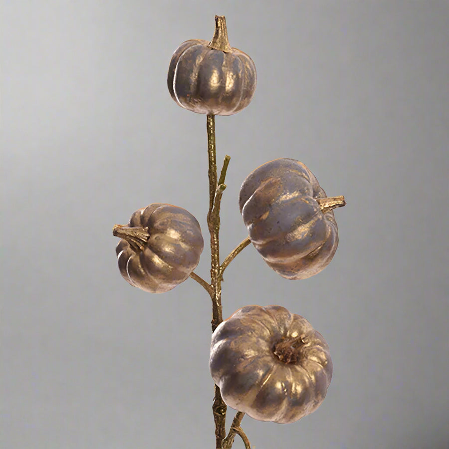 Részletfotó a Pumpkin kollekció kékarany mű dísztök ágáról, csillogó, antikolt felületű dekorációs tökökkel.