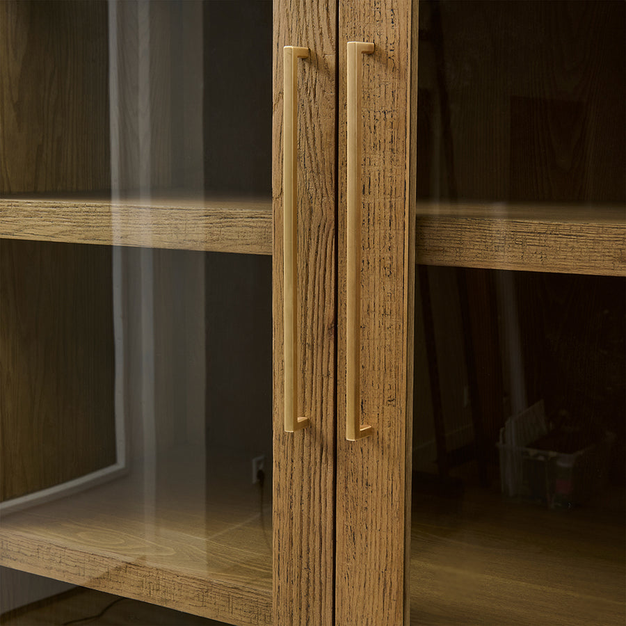 Üveges vitrines ajtók arany fogantyúkkal közelről