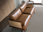 Barna színű marhabőrrel kárpitozott, rattanbetétes, 3 személyes design kanapé.