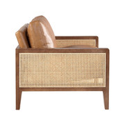 Konyakbarna színű marhabőrrel kárpitozott, rattanbetétes design fotel.