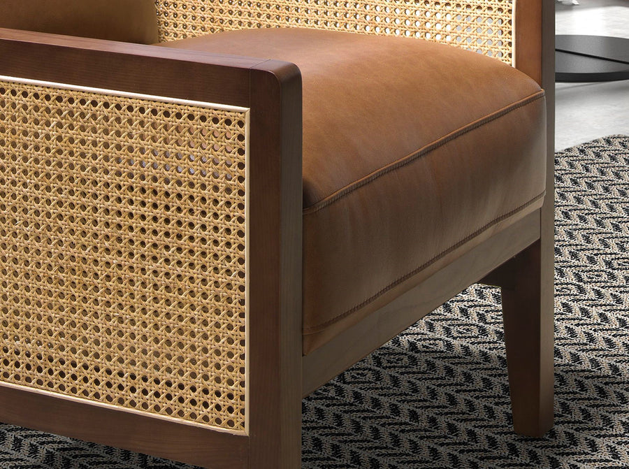 Konyakbarna színű marhabőrrel kárpitozott, rattanbetétes design fotel.